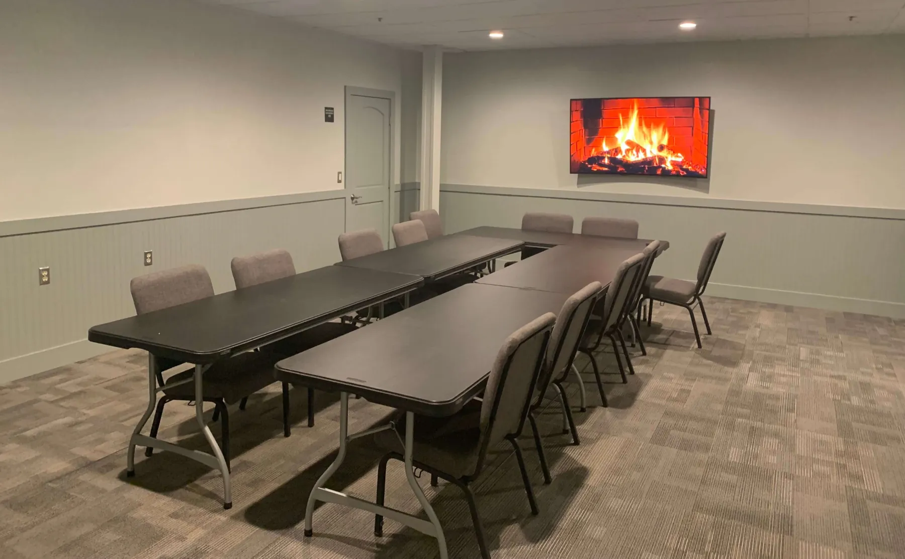 The private meeting room at Third Shot Coffee with a long table and wall-mounted TV